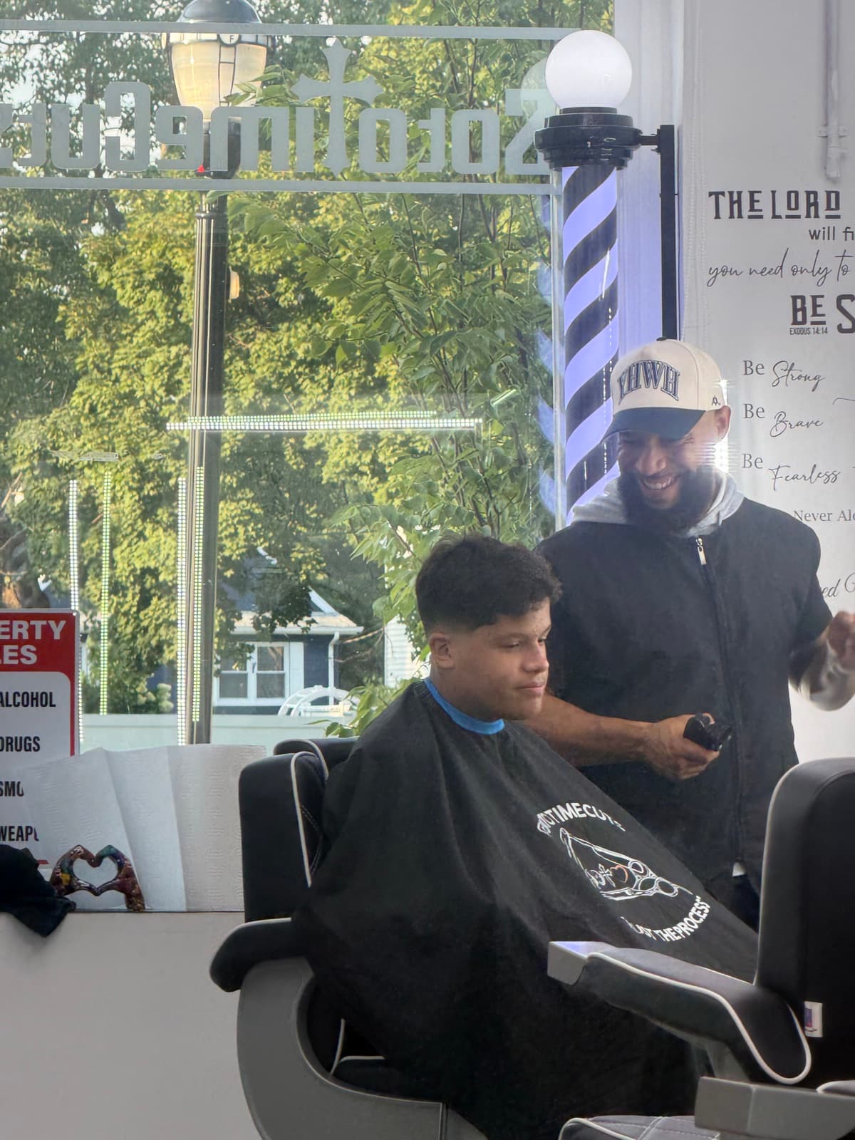 Taper haircut in progress next to the barber pole at Soto Time Cuts